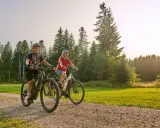 Para, jak wybrać rower elektryczny, cieszy się jazdą po leśnej ścieżce.