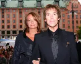 Gessle, ung och stilig, poserar med en kvinna framför en byggnad i Stockholm.