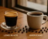 Long Black vs Americano: zwei Kaffeegetränke auf einem Holztisch, umgeben von Kaffeebohnen.