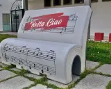 Ławka w kształcie książki z nutami i napisem "Bella Ciao". To symbol wolności i oporu, który znaczy "żegnaj piękna".