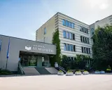 Akademia Humanitas w Katowicach, gdzie można studiować psychologię. Budynek z zielenią i parkingiem.