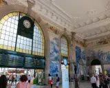 Der Bahnhof Porto mit seinen beeindruckenden Azulejo-Kacheln und einer großen Anzeigetafel.