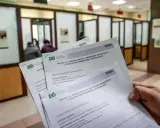 Dłoń trzyma formularze ZUS dotyczące wniosku o rodzicielskie świadczenie uzupełniające. To krok do ponownego przeliczenia emerytury ze względu na długość życia.