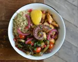 Un plat coloré avec du poulpe grillé, du quinoa, des légumes rôtis et une touche de citron. La marinade pour poulpe grillé a sublimé ce plat.