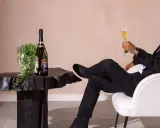 Ein Mann im Anzug genießt Champagner. Die aufwendige Herstellung erklärt, warum ist Champagner so teuer.