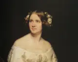 Porträtt av en ung kvinna med blommor i håret, kanske en ung Jenny Lind.
