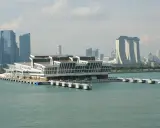Moderno terminal crociere galleggiante nel **singapore porto**, con grattacieli iconici sullo sfondo.