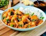Herzhaftes Aloo Gobi mit Blumenkohl und Kartoffeln in würziger Tomatensauce, garniert mit Koriander und serviert mit Reis.