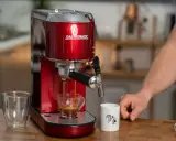 Rote Kaffeemaschine brüht Espresso mit Crema. Eine normale Kaffeemaschine für den perfekten Start in den Tag.