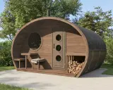 Fasssauna aus thermisch modifiziertem Holz mit runden Fenstern und Holzstapel.