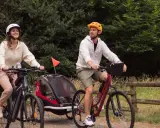 Para wycieczka rowerowa z dzieckiem w przyczepce. Zastanawiasz się, jakie buty na rower będą najlepsze? Oni wybrali wygodne sportowe obuwie.