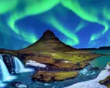 Islandia najpiękniejsze miejsca: góra Kirkjufell i wodospad pod tańczącą zorzą polarną.