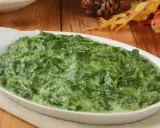 Un plat de épinards à la crème crémeux et appétissant dans un plat blanc, prêt à être dégusté.