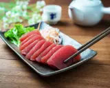 Väl förberedd tonfisk sashimi på en tallrik, redo att avnjutas med en god vin. En klassisk kombination för en lyxig måltid.