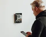 Man med mobil kontrollerar enhet för energisk lastbalansering via wifi.