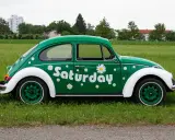 Zielony Garbus z napisem "Saturday" i stokrotkami. Idealny na dzień wolny za święto w sobotę.