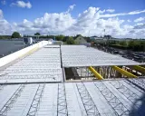 Budowa nowego stropu z prefabrykatów. Metalowe kratownice czekają na beton.