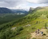 Vandrare njuter av utsikten över Sarek nationalpark, med en vidsträckt dalgång och slingrande floder.