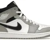 Szary i biały but sportowy, przypominający jordan 1 fake, z czarnym logo i sznurówkami.