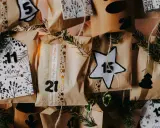 Bożonarodzeniowy kalendarz z datami, ozdobiony gałązkami i błyszczącymi taśmami. Widoczne numery 5, 11, 15, 21, 12.