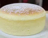 Un délicieux cheesecake japonais, léger et aérien, saupoudré de sucre glace sur une assiette blanche.