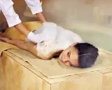 Eine Frau genießt eine Schaummassage im Hamam. Die Bedeutung von Hamam liegt in der tiefen Entspannung und Reinigung.