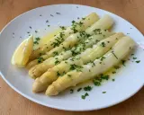 Vitt sparris med smält smör, persilja och en citronklyfta. Perfekt sparris koktid för en lätt och god rätt.