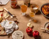 Un plateau gourmand avec camembert, pain, beurre, pommes et tarte aux pommes, une spécialité normandie.