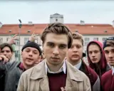 Grupa młodych ludzi przed budynkiem liceum. Czy to właśnie do jakiego liceum chodził Mata?