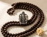 En silverring med Ganesha, omgiven av ett radband av träpärlor. En symbol för visdom och lycka, perfekt för att recitera ganesha mantra.