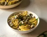 Un invitante piatto di spaghetti alle vongole, con pasta dorata e molluschi freschi, guarnito con prezzemolo.