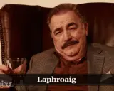 Mann mit Schnurrbart hält Glas Whisky. Die Laphroaig Aussprache ist wichtig für Kenner.