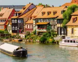 Bunte Fachwerkhäuser säumen das Wasser, Boote schaukeln sanft. Ein malerischer Anblick, der die vielen Attraktionen Bayerns widerspiegelt.