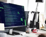 Tester oprogramowania analizuje kod na ekranie komputera.