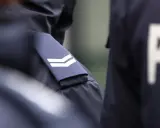 Zbliżenie na mundur policyjny z naszywkami i literami "PO".