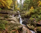 Herbstliche Szenerie mit Wasserfall und Holzbrücken im Bayerischen Wald. Perfekt für Ausflugsziele.