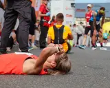 Zmęczona biegaczka leży na ziemi po tym, jak dowiedziała się, ile biegnie się maraton.