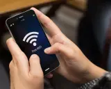 Person versucht, das Handy mit dem WLAN zu verbinden, aber es klappt nicht. Das WLAN-Symbol leuchtet auf dem Bildschirm.