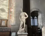 Statue de David par David Verrocchio, debout sur la tête de Goliath, dans un musée.