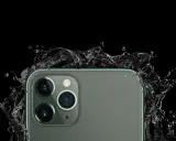 El iPhone 11, con sus cámaras de 12 megapíxeles, resiste salpicaduras de agua en un fondo negro.