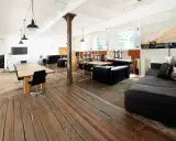 Geräumiges Loft mit Holzboden, großen Fenstern, Arbeitsbereich und gemütlicher Sitzecke. Eine perfekte loft definition.