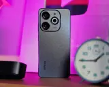 Szary smartfon Infinix z potrójnym aparatem na tle różowego światła. Czy to Infinix co to za firma?
