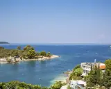 Piękna zatoka w Ksamil, Albania, z turkusową wodą, zielonymi wyspami i białym hotelem. Idealne miejsce na wakacje.
