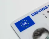 Brytyjskie prawo jazdy. Czy można jeździć oczekując na wymianę prawo jazdy? Dokument z flagą UK.