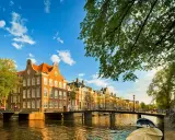 Un paseo por los canales de Amsterdam con adolescentes, disfrutando de las casas históricas y el sol.