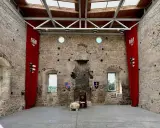Wnętrze zamku w Szydłowie. Czerwone banery z orłami i herbami, tron. Sprawdź cennik zwiedzania!