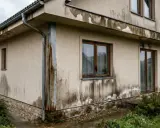 Brudne ślady po deszczu na elewacji, gdzie woda cieknie po ścianie, tworząc nieestetyczne zacieki.