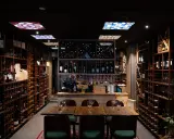 En vinbar med hyllor fyllda med flaskor, redo för en kväll med pasion tapas och goda viner.