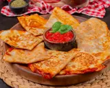 Goldbraune Quesadillas, gefüllt mit geschmolzenem Käse und Tomaten, serviert mit frischem Basilikum. Ein einfaches Quesadillas Rezept für jeden Anlass.