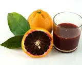 Blutorange: ein gesunder Genuss für gesund abnehmen. Saft und Frucht mit Blättern auf weißem Grund.